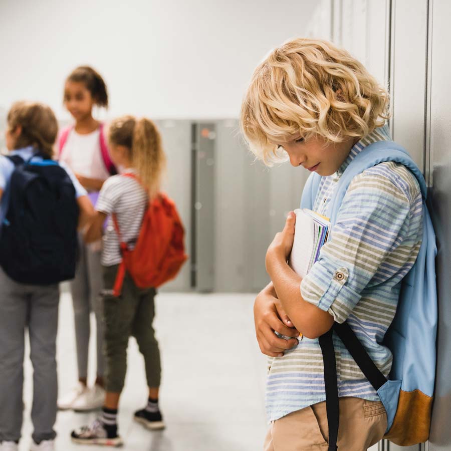 Kind mit Lese-Rechtschreibschwierigkeiten am Rand einer Kindergruppe